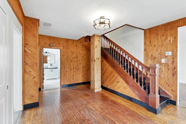 44 E Taylor St, Huntington, IN 46750 - staircase with wooden walls, hardwood / wood-style flooring, and baseboards