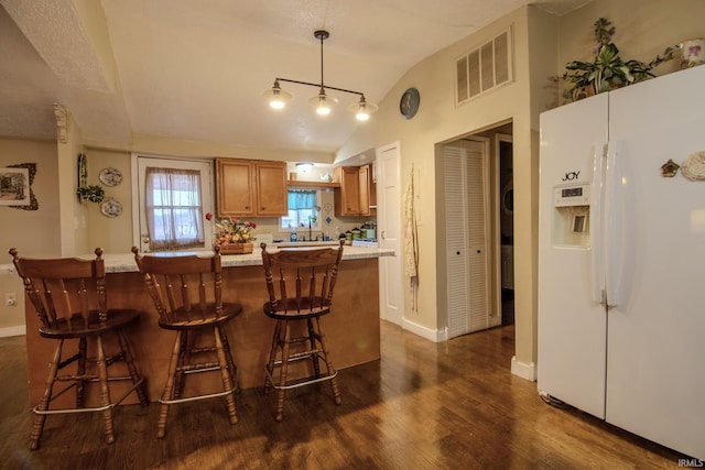 4555 E 250 S, Knox, IN 46534 - kitchen featuring white fridge with ice dispenser, light countertops, dark wood-type flooring, lofted ceiling, and brown cabinets