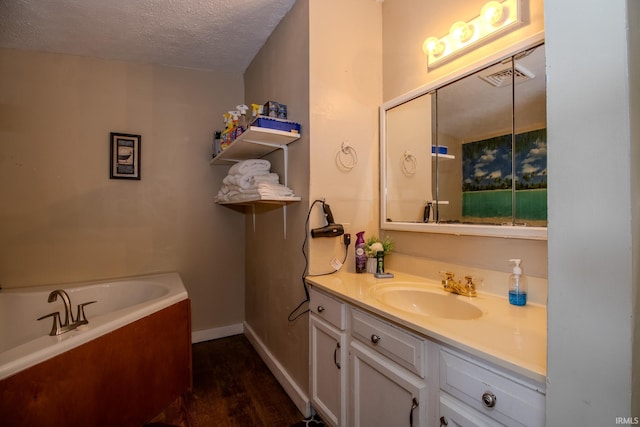 4555 E 250 S, Knox, IN 46534 - full bathroom featuring a garden tub, a textured ceiling, vanity, wood finished floors, and baseboards