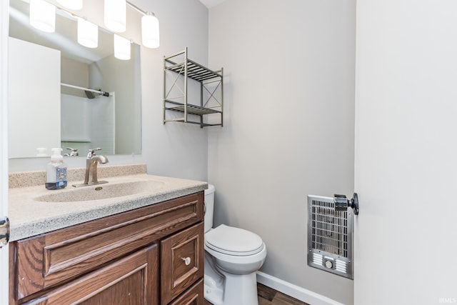 3608 W 31st St, Muncie, IN 47302 - bathroom featuring heating unit, vanity, toilet, a shower, and wood finished floors