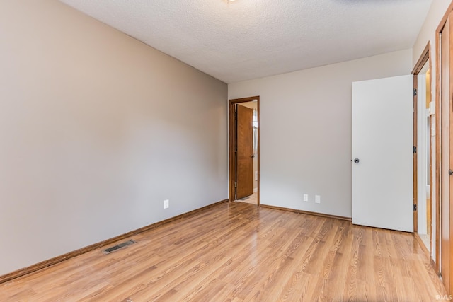 3608 W 31st St, Muncie, IN 47302 - unfurnished bedroom featuring light wood-type flooring, a textured ceiling, and baseboards