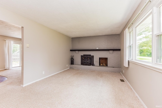 3608 W 31st St, Muncie, IN 47302 - unfurnished living room with carpet, a wood stove, and baseboards