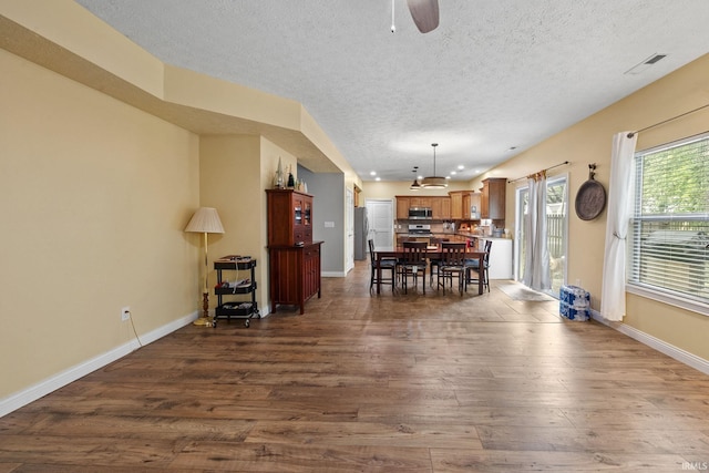 4665 S 150 E, Lafayette, IN 47909 - dining area featuring dark wood-type flooring, a textured ceiling, a ceiling fan, and baseboards