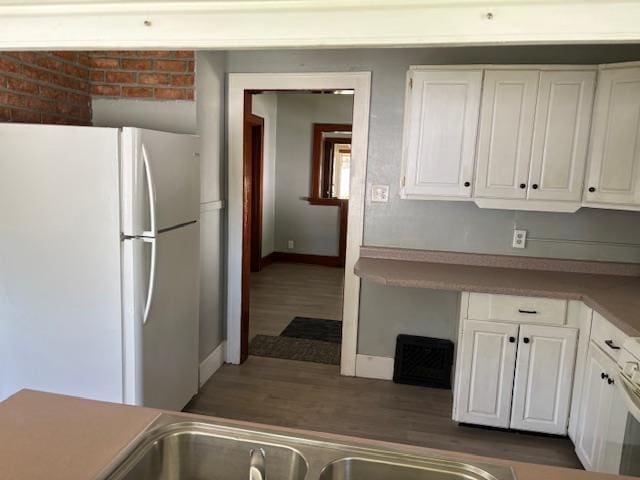 1515 E Donald St, South Bend, IN 46613 - kitchen with freestanding refrigerator, white cabinetry, baseboards, and dark wood-style flooring