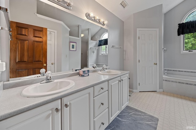 56 Jester Ct, Lafayette, IN 47905 - bathroom featuring vaulted ceiling, double vanity, a relaxing tiled tub, and baseboards