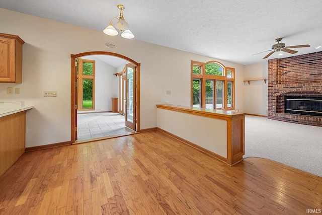 56 Jester Ct, Lafayette, IN 47905 - unfurnished living room with ceiling fan, plenty of natural light, light wood finished floors, arched walkways, and a textured ceiling