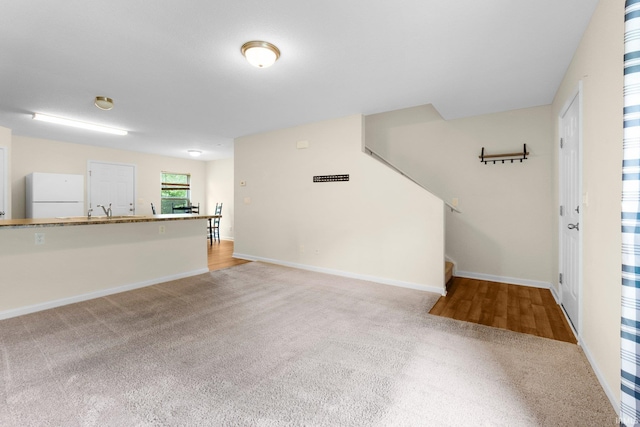 496 Arbor Ln, Huntington, IN 46750 - unfurnished living room with carpet flooring, baseboards, and a sink