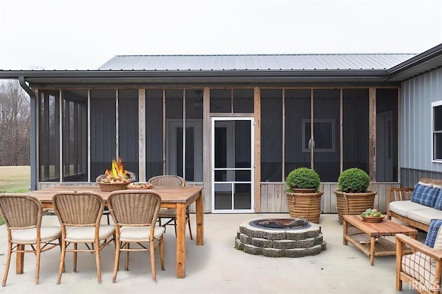 1230 S Iron Mountain Rd, Bloomfield, IN 47424 - view of patio featuring a sunroom, outdoor dining space, and an outdoor living space with a fire pit
