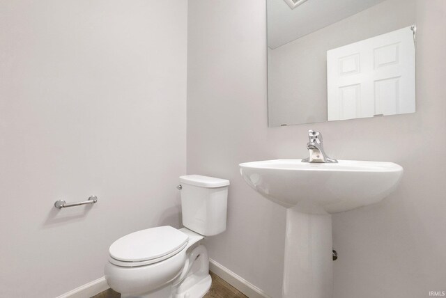 1001 Nicholas Trl, Fremont, IN 46737 - bathroom featuring baseboards, toilet, and a sink