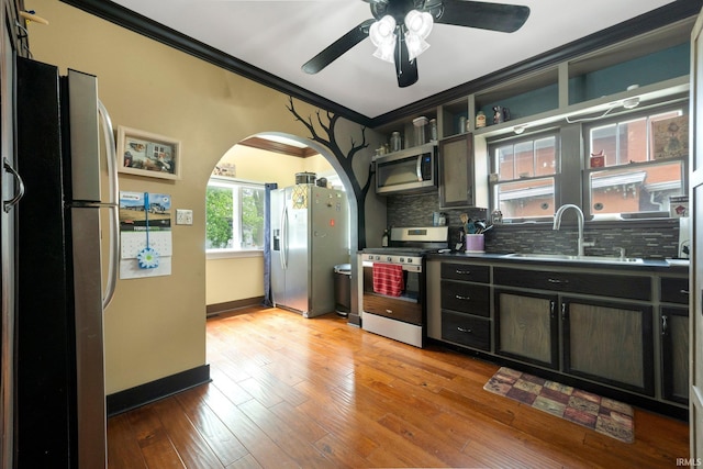 285 N Center St, Waterloo, IN 46793 - kitchen featuring stainless steel appliances, a sink, open shelves, ornamental molding, and arched walkways