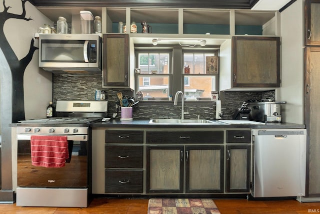 285 N Center St, Waterloo, IN 46793 - kitchen featuring appliances with stainless steel finishes, a sink, backsplash, dark countertops, and wood finished floors