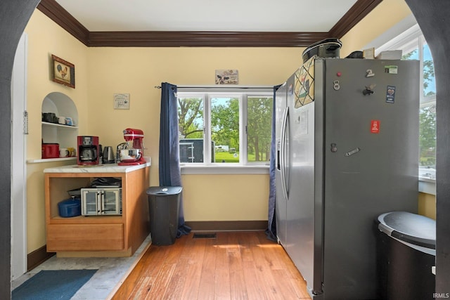 285 N Center St, Waterloo, IN 46793 - kitchen featuring stainless steel fridge, crown molding, light wood-style flooring, baseboards, and light countertops