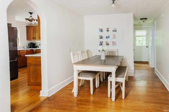 5889 E 46th Rd, Bloomington, IN 47408 - dining area featuring light wood-style flooring, arched walkways, and baseboards