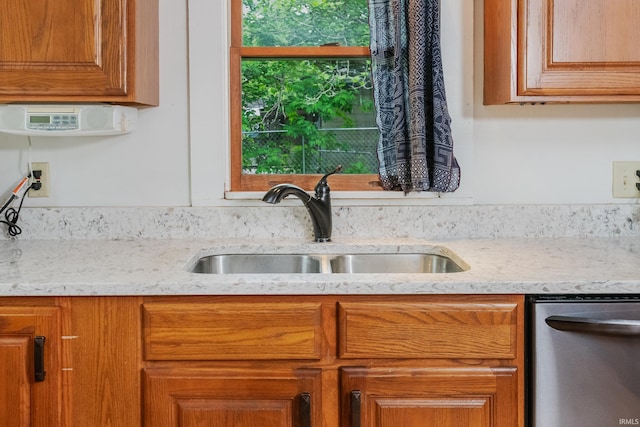 5889 E 46th Rd, Bloomington, IN 47408 - kitchen featuring dishwasher, a sink, light stone counters, and brown cabinetry