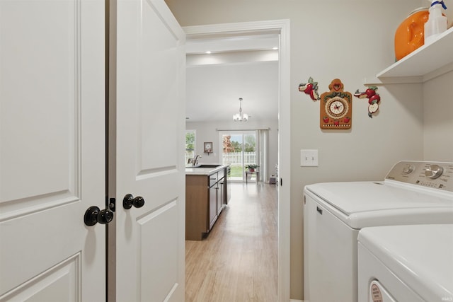 3436 Fawn Creek Blvd, Waterloo, IN 46793 - laundry area with washing machine and dryer, light wood-style floors, and a chandelier