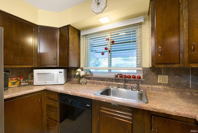 4112 Hiawatha Blvd, Fort Wayne, IN 46809 - kitchen with black dishwasher, white microwave, a sink, decorative backsplash, and dark brown cabinetry