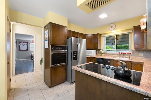 4112 Hiawatha Blvd, Fort Wayne, IN 46809 - kitchen with oven, stainless steel fridge, a sink, dishwasher, and light tile patterned floors