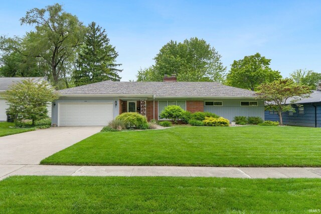 4112 Hiawatha Blvd, Fort Wayne, IN 46809 - ranch-style house featuring an attached garage, a chimney, a front lawn, driveway, and brick siding