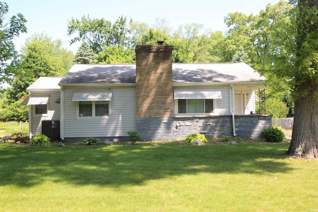 19511 Eaton Ave, South Bend, IN 46637 - rear view of property featuring a chimney, a yard, and central AC