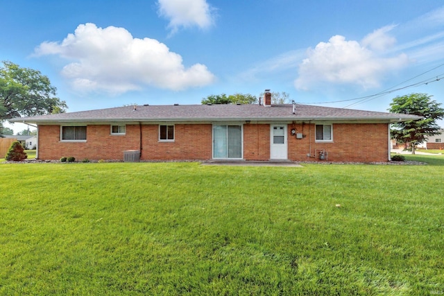 928 Hollyhill Dr, Fort Wayne, IN 46819 - rear view of house with a chimney, a lawn, brick siding, cooling unit, and a shingled roof
