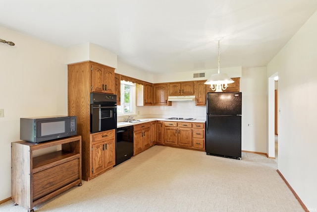 928 Hollyhill Dr, Fort Wayne, IN 46819 - kitchen with black appliances, under cabinet range hood, brown cabinetry, light colored carpet, and hanging light fixtures