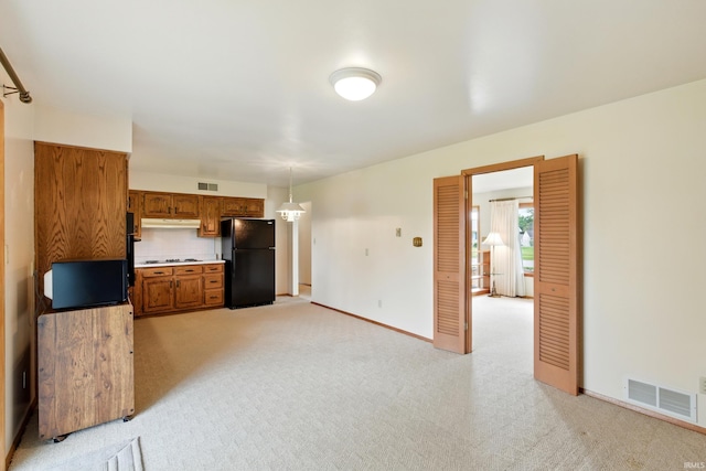 928 Hollyhill Dr, Fort Wayne, IN 46819 - kitchen with freestanding refrigerator, light carpet, brown cabinetry, and light countertops