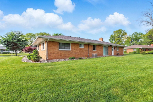 928 Hollyhill Dr, Fort Wayne, IN 46819 - back of property with cooling unit, brick siding, a chimney, and a yard