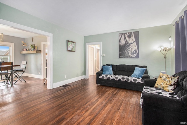 402 W Waterford St, Wakarusa, IN 46573 - living area featuring dark wood-style flooring and baseboards