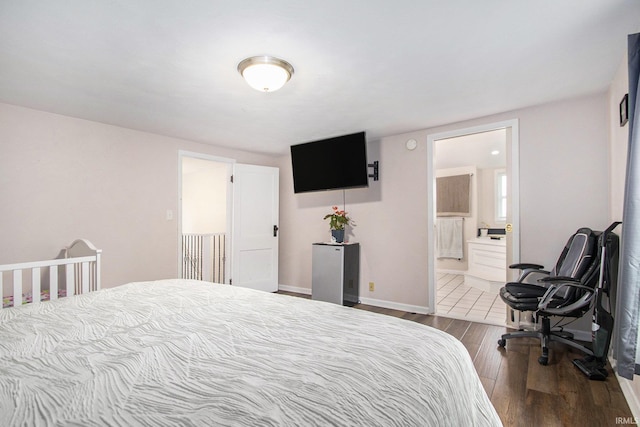 402 W Waterford St, Wakarusa, IN 46573 - bedroom featuring dark wood-type flooring, baseboards, connected bathroom, and a desk