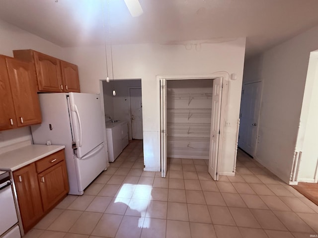 53172 Bracken Fern Dr, South Bend, IN 46637 - kitchen with independent washer and dryer, light countertops, freestanding refrigerator, light tile patterned floors, and stove