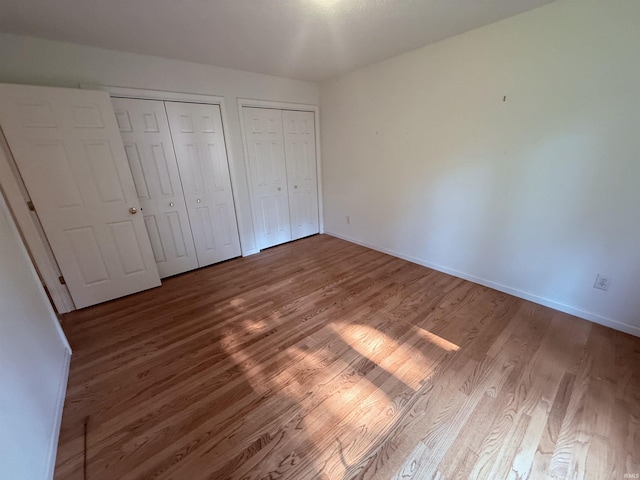 53172 Bracken Fern Dr, South Bend, IN 46637 - unfurnished bedroom with wood finished floors, multiple closets, and baseboards