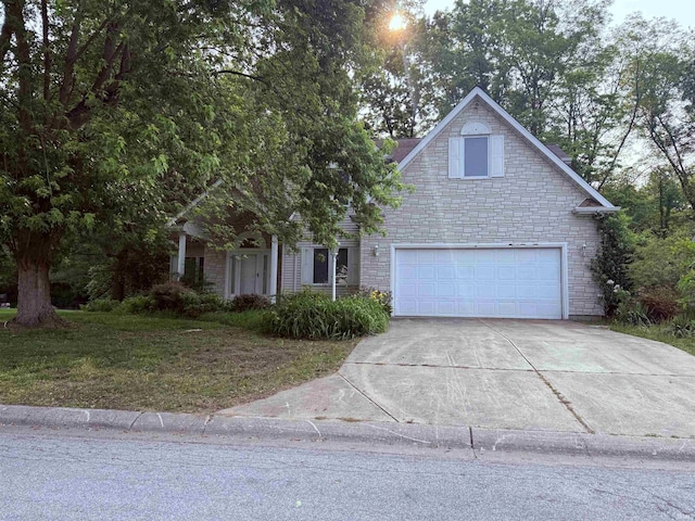 53172 Bracken Fern Dr, South Bend, IN 46637 - view of front of house with driveway, a garage, stone siding, and a front yard