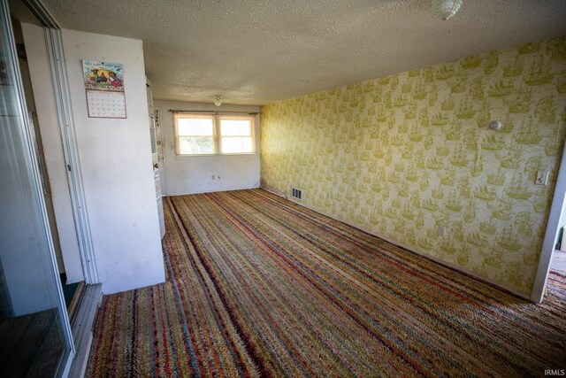 401 S Plymouth St, Culver, IN 46511 - carpeted empty room with wallpapered walls and a textured ceiling