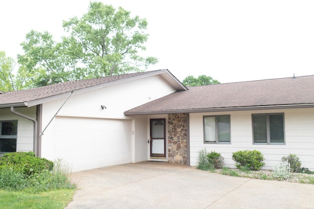 604 W Soutar Dr, Bloomington, IN 47403 - view of front of home with concrete driveway, a garage, roof with shingles, and stone siding