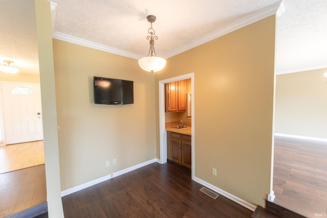 604 W Soutar Dr, Bloomington, IN 47403 - unfurnished living room featuring dark wood finished floors, a sink, crown molding, baseboards, and a textured ceiling