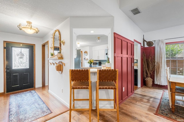 15025 Water Oak Pl, Huntertown, IN 46748 - entryway featuring light wood-style floors, baseboards, and a textured ceiling