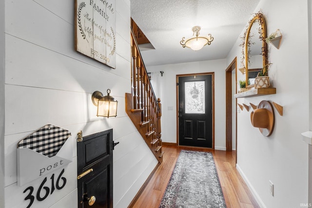 15025 Water Oak Pl, Huntertown, IN 46748 - foyer featuring stairs, light wood-style floors, baseboards, and a textured ceiling