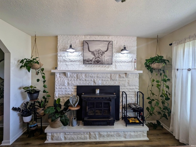 1406 N 800 E, Greentown, IN 46936 - detailed view of wood finished floors, baseboards, a wood stove, and a textured ceiling