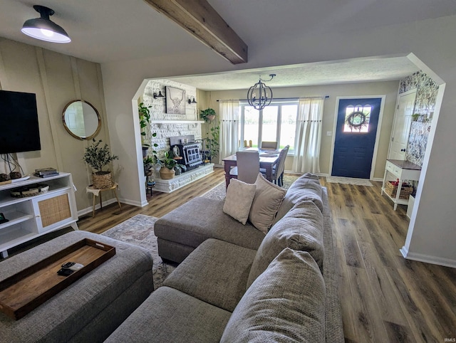 1406 N 800 E, Greentown, IN 46936 - living room with baseboards, wood finished floors, a chandelier, beamed ceiling, and a fireplace