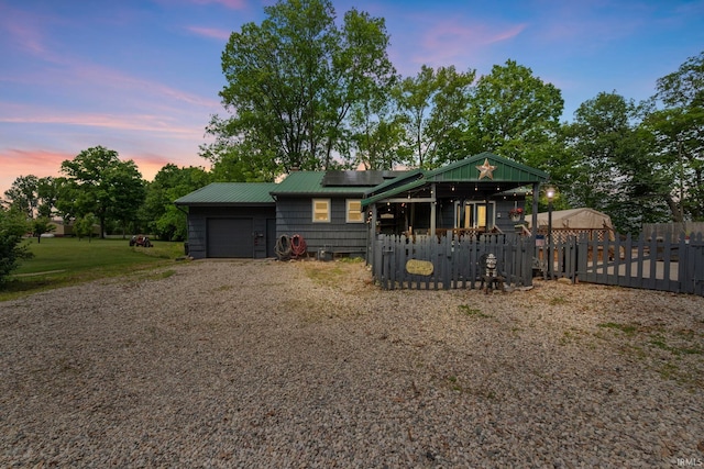 2526 S Airport Rd, Monticello, IN 47960 - view of front of house with solar panels, an attached garage, gravel driveway, and metal roof