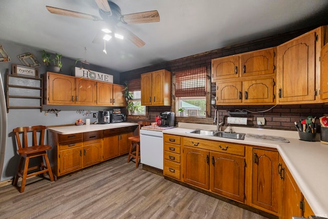 2526 S Airport Rd, Monticello, IN 47960 - kitchen featuring a sink, a ceiling fan, light countertops, light wood-type flooring, and brown cabinetry