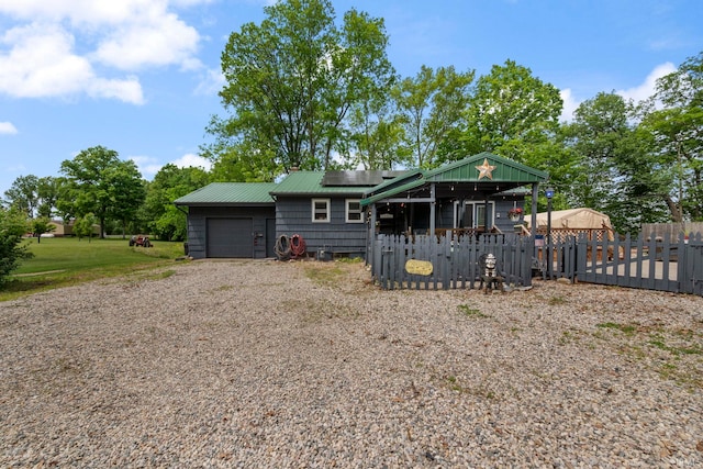 2526 S Airport Rd, Monticello, IN 47960 - view of front of home featuring a garage, roof mounted solar panels, driveway, and metal roof