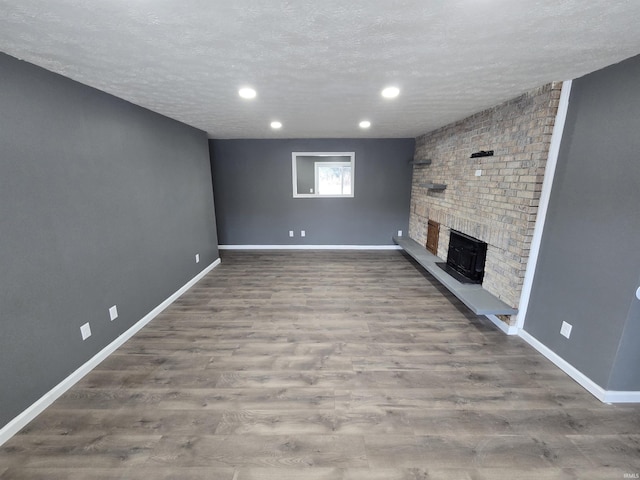 2914 Marian Ave, Lafayette, IN 47905 - unfurnished living room with a fireplace, a textured ceiling, wood finished floors, baseboards, and recessed lighting