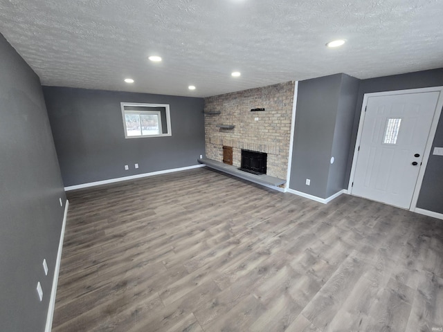 2914 Marian Ave, Lafayette, IN 47905 - unfurnished living room featuring a textured ceiling, a fireplace, wood finished floors, recessed lighting, and baseboards