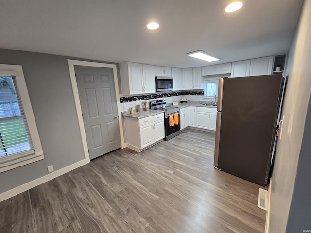 900 S 28th St, Lafayette, IN 47904 - kitchen featuring appliances with stainless steel finishes, a sink, white cabinetry, light wood-style floors, and recessed lighting