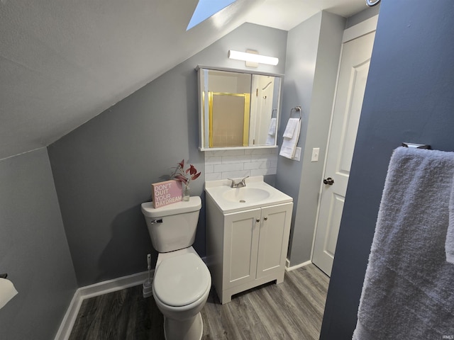900 S 28th St, Lafayette, IN 47904 - bathroom featuring wood finished floors, vanity, a skylight, toilet, and vaulted ceiling