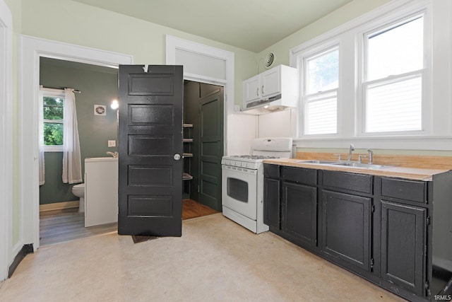 3422 S Calhoun St, Fort Wayne, IN 46807 - kitchen with white gas stove, a sink, under cabinet range hood, and plenty of natural light