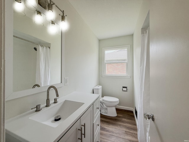 2425 Ojibway Trl, Fort Wayne, IN 46809 - bathroom with vanity, toilet, wood finished floors, baseboards, and curtained shower
