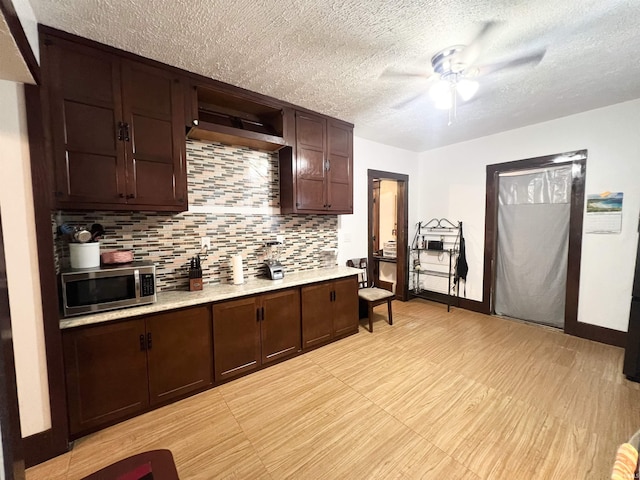 400 Burlington Ave, Logansport, IN 46947 - kitchen featuring stainless steel microwave, a ceiling fan, light countertops, a textured ceiling, and tasteful backsplash