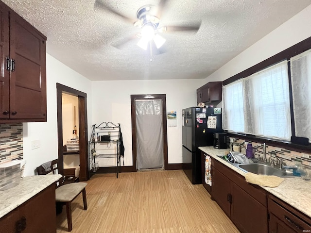 400 Burlington Ave, Logansport, IN 46947 - kitchen featuring a sink, light wood finished floors, backsplash, a ceiling fan, and freestanding refrigerator